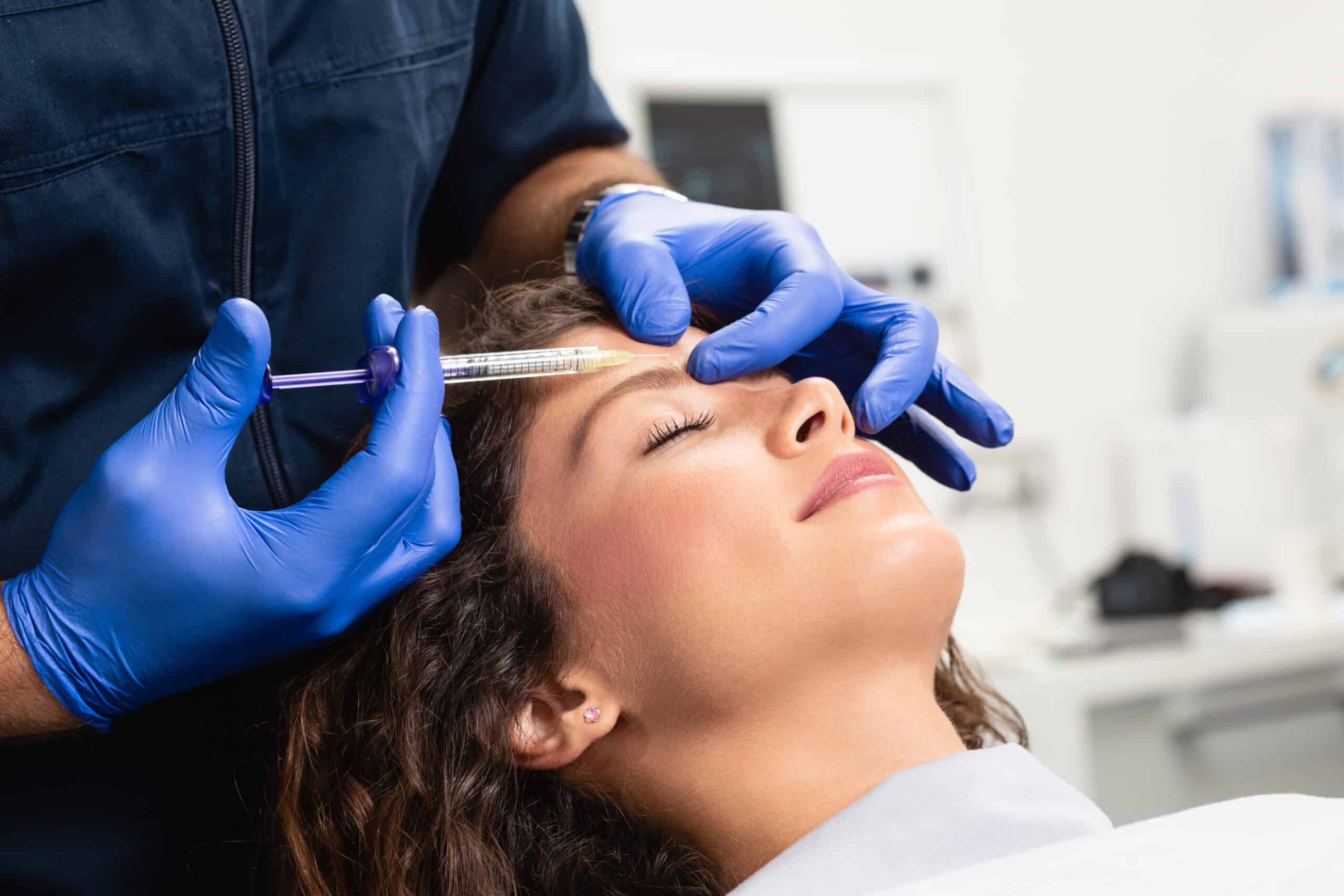 Close up of beautician expert's hands injecting botox in Birmingham