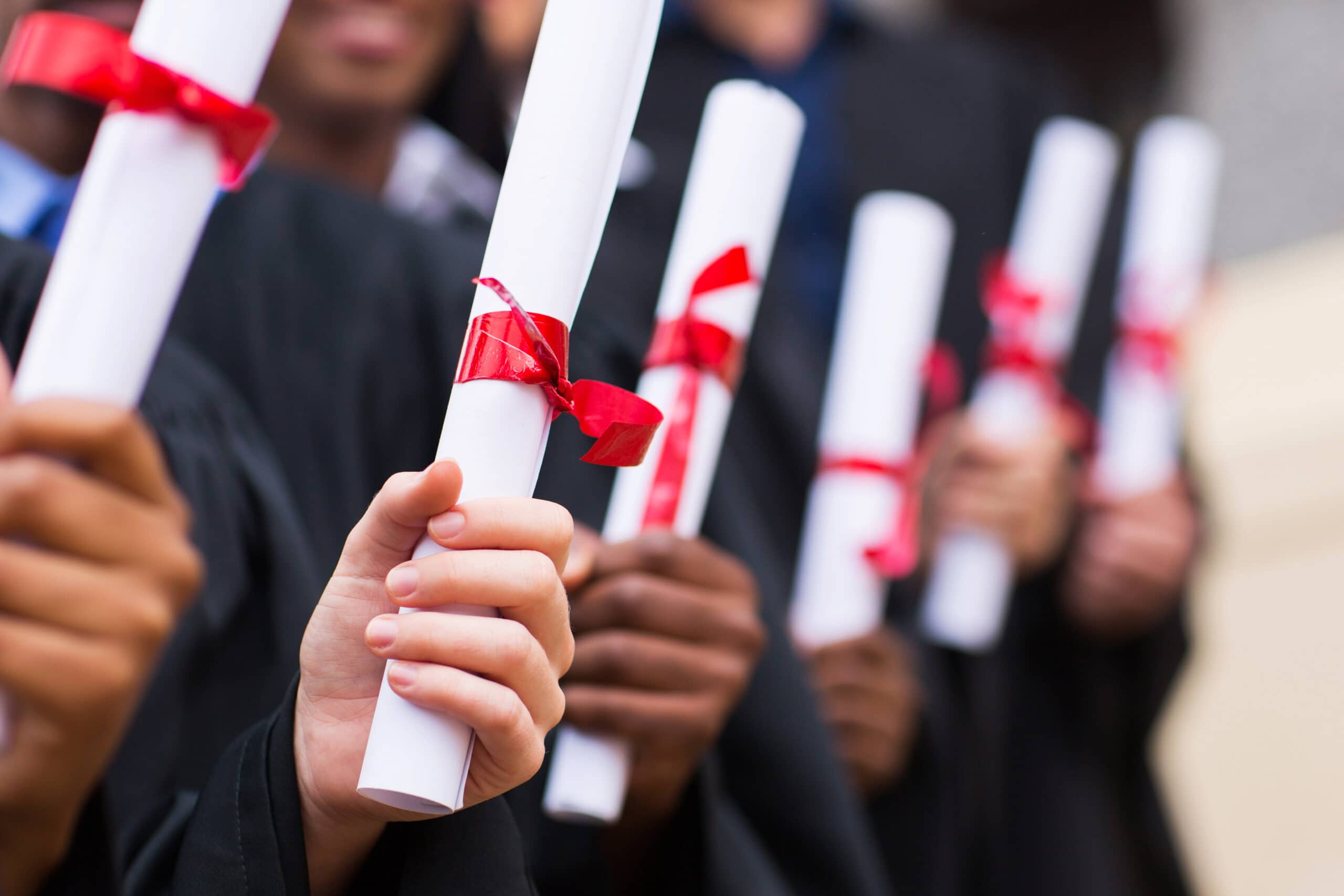 group of multiracial graduates holding level 7 diploma